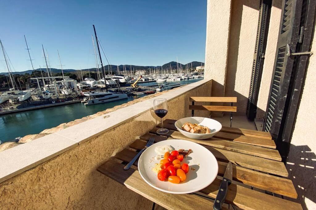 uma mesa com dois pratos de comida e um copo de vinho em Modern Appartement - Les Pieds dans l'Eau - Saint-Tropez 4 em Cogolin