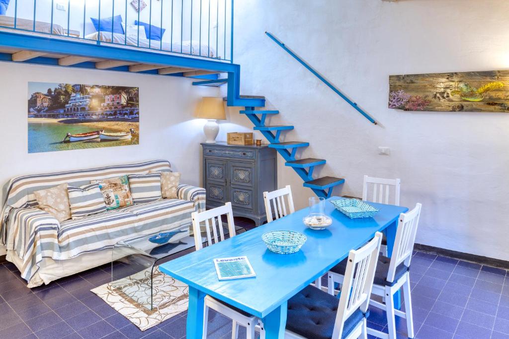 a living room with a blue table and a staircase at IVANA Apartment in Levanto
