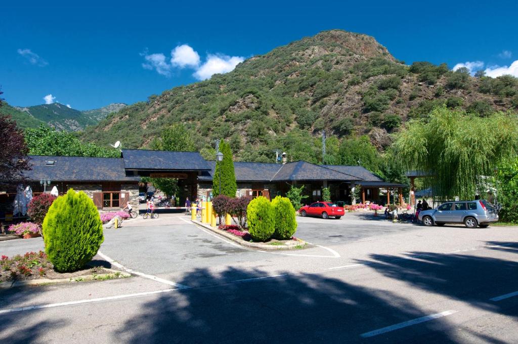 a parking lot in front of a mountain at Camping Bungalows La Borda del Pubill in Ribera de Cardós