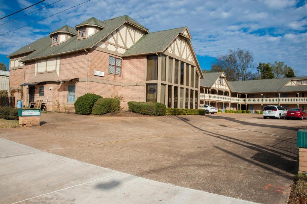 a large brick building with a parking lot in front of it at Victorian Inn & Suites in Nacogdoches