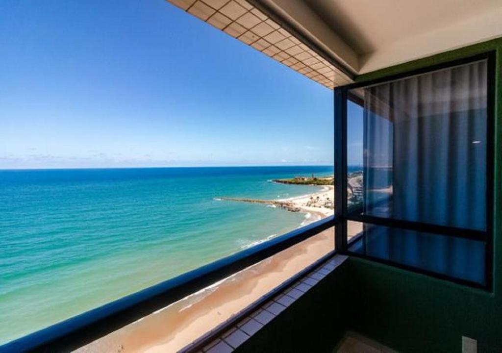 a room with a view of the ocean from a balcony at Golden Tower in Natal