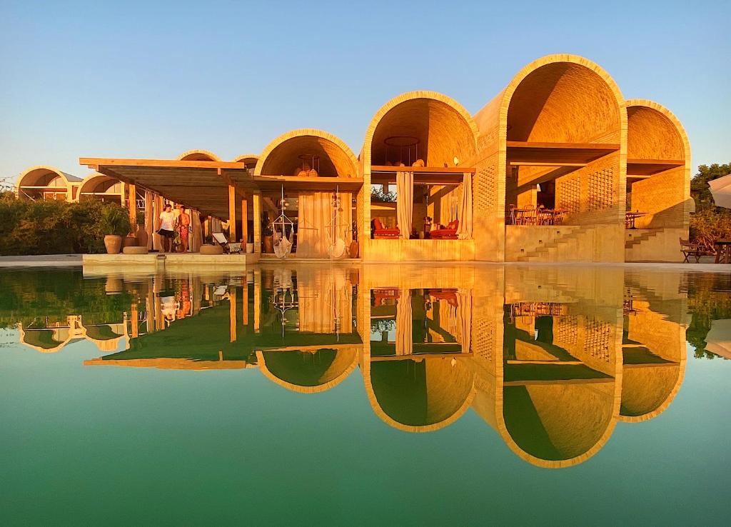 une maison avec sa réflexion dans l'eau dans l'établissement Casona Sforza, à Puerto Escondido