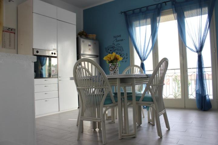 a kitchen with a table and chairs and a kitchen with a window at Maré - Scala dei Turchi in Realmonte