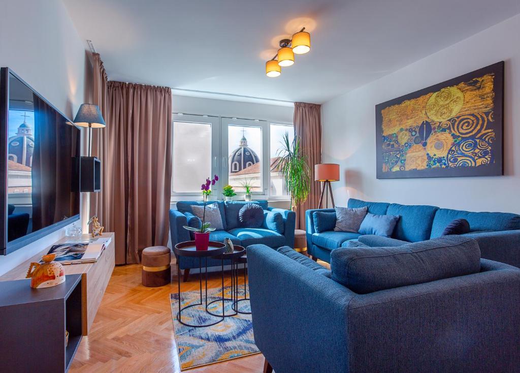 a living room with blue couches and a tv at Deluxe City Center Blue apartment in Split