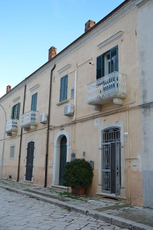 un grand bâtiment avec 2 balcons dans une rue dans l'établissement Dimora Sole Raggiante, à Venosa