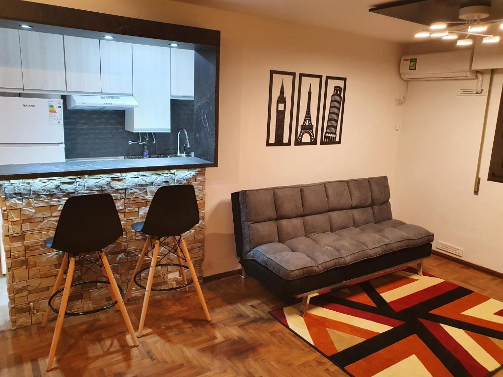 sala de estar con sofá y 2 sillas en Alojamiento Maria :-) en Córdoba