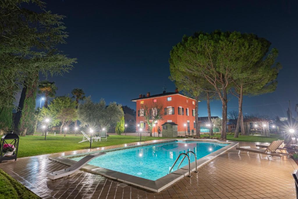 - une piscine en face d'une maison la nuit dans l'établissement DOLF - Villa Elisa, à Tolentino