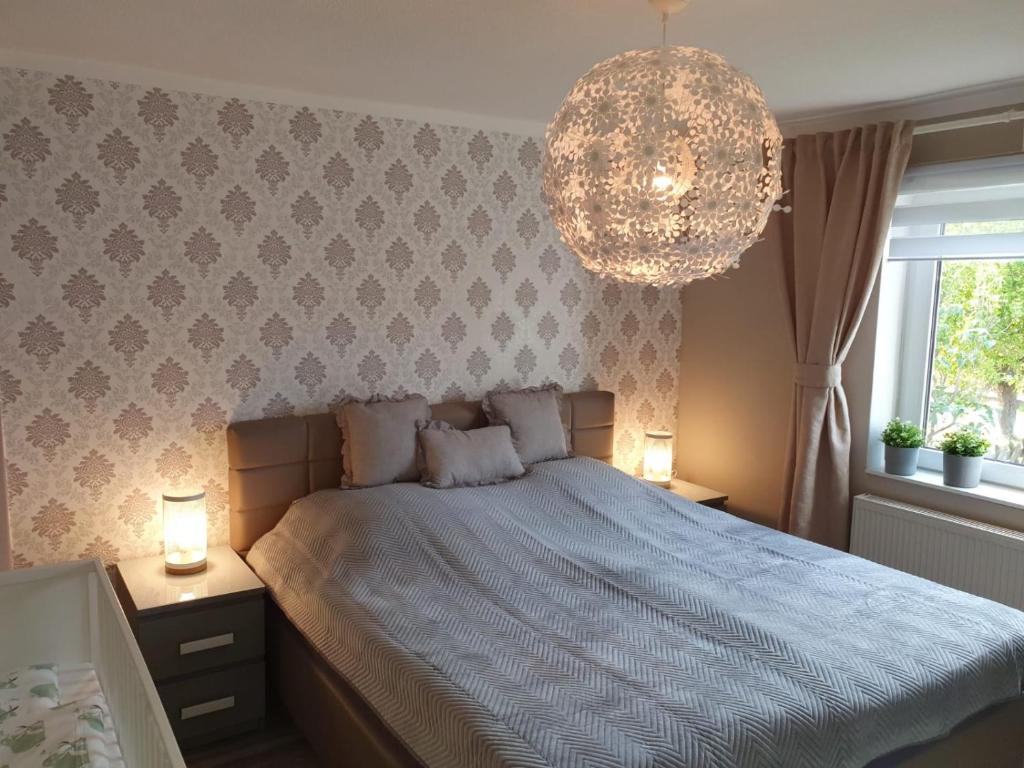 - une chambre avec un grand lit et un lustre dans l'établissement Dein Ferienhaus in Wernigerode, à Wernigerode