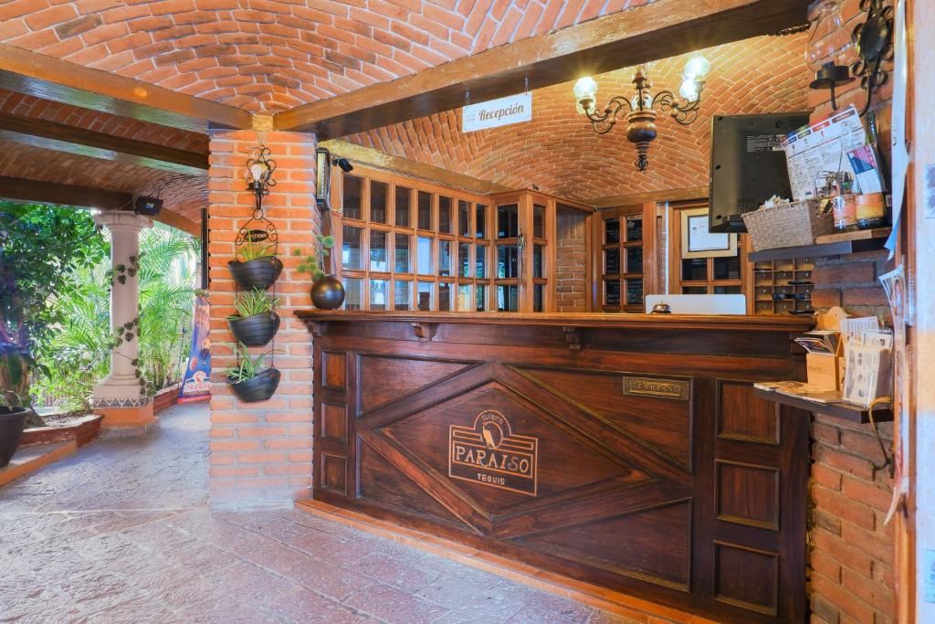 eine Bar mit Holztür und Ziegelwand in der Unterkunft Suites Paraiso Tequis in Tequisquiapan