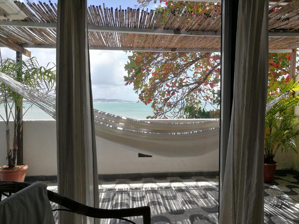 Habitación con vistas al océano a través de una ventana en Coco Beach Apart, en Natal