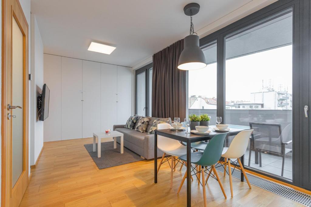 布拉格的住宿－Apartment Oscar with garage，用餐室以及带桌椅的起居室。