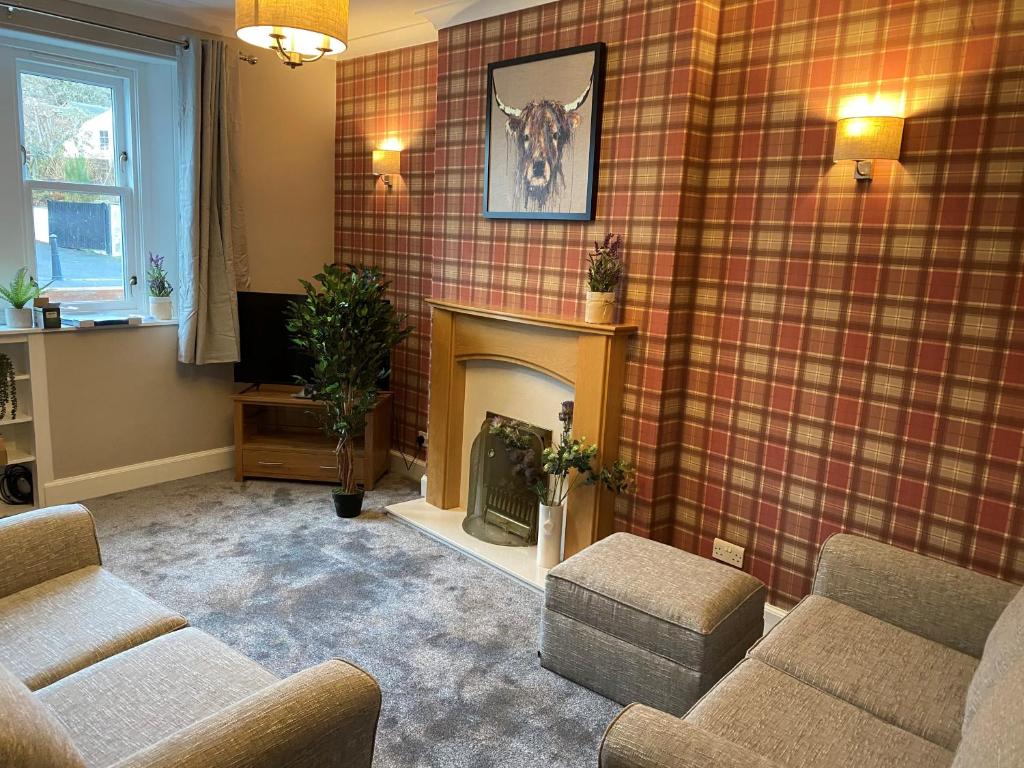 a living room with two couches and a fireplace at Pergola Cottage in Melrose