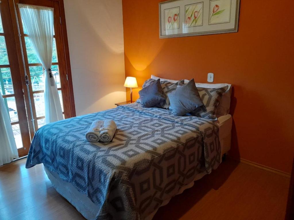 Un dormitorio con una cama con zapatos. en Pousada Monte Suiço, en Campos do Jordão