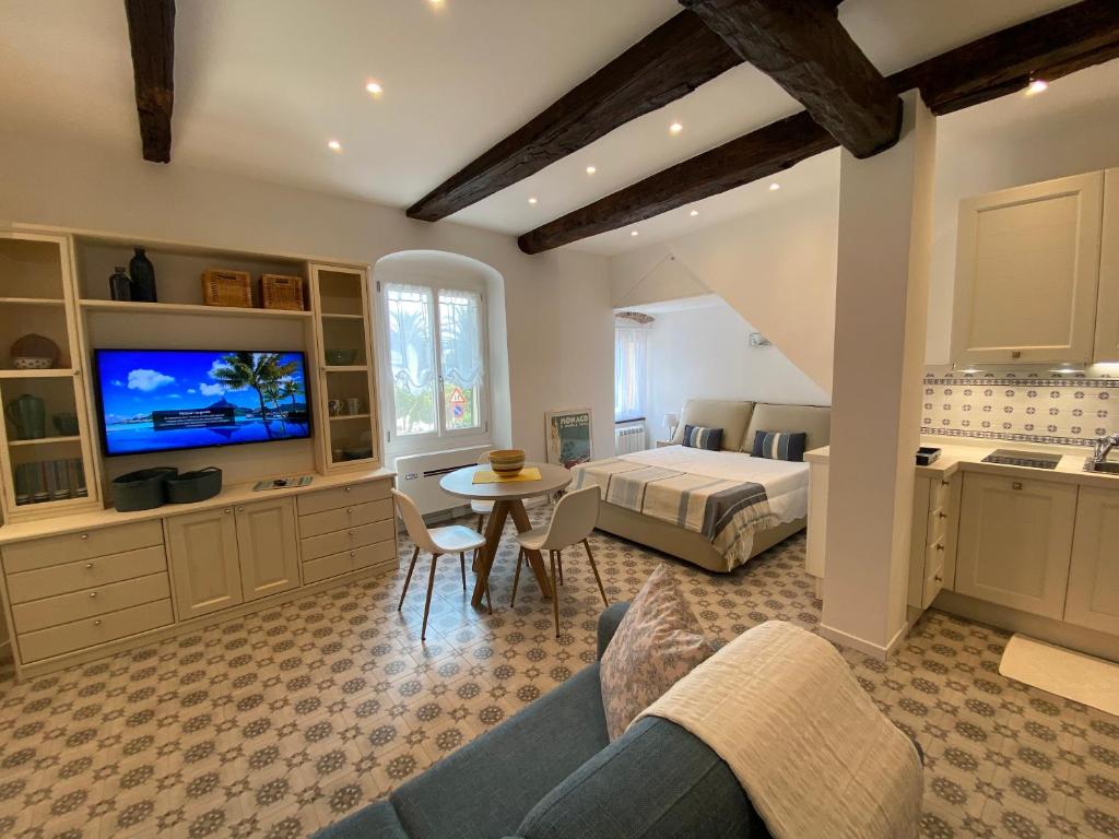 1 dormitorio con 1 cama y sala de estar con TV. en Suite 5 stelle nel Borgo di Celle Ligure, en Celle Ligure
