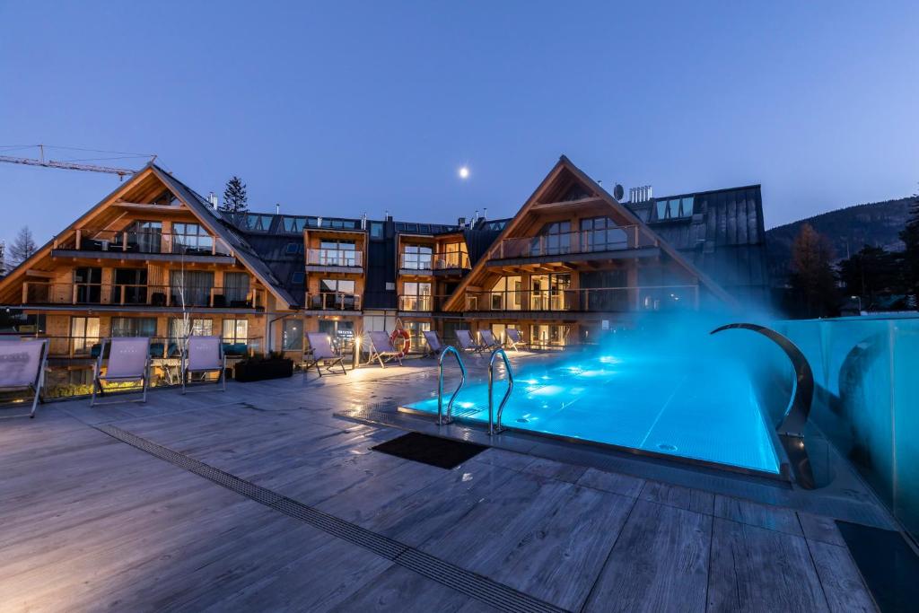 un hotel con piscina frente a un edificio en APARTHOTEL ROYAL RESORT SPA Zakopane en Zakopane