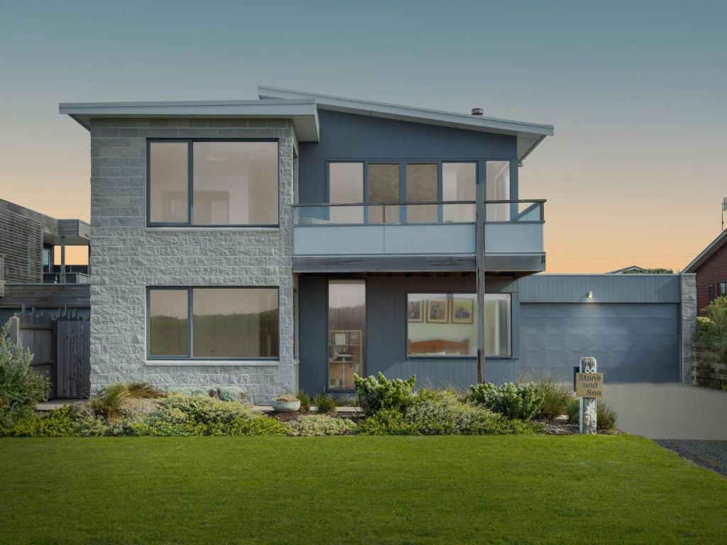 a house with a green lawn in front of it at Stone and Sea in Port Fairy