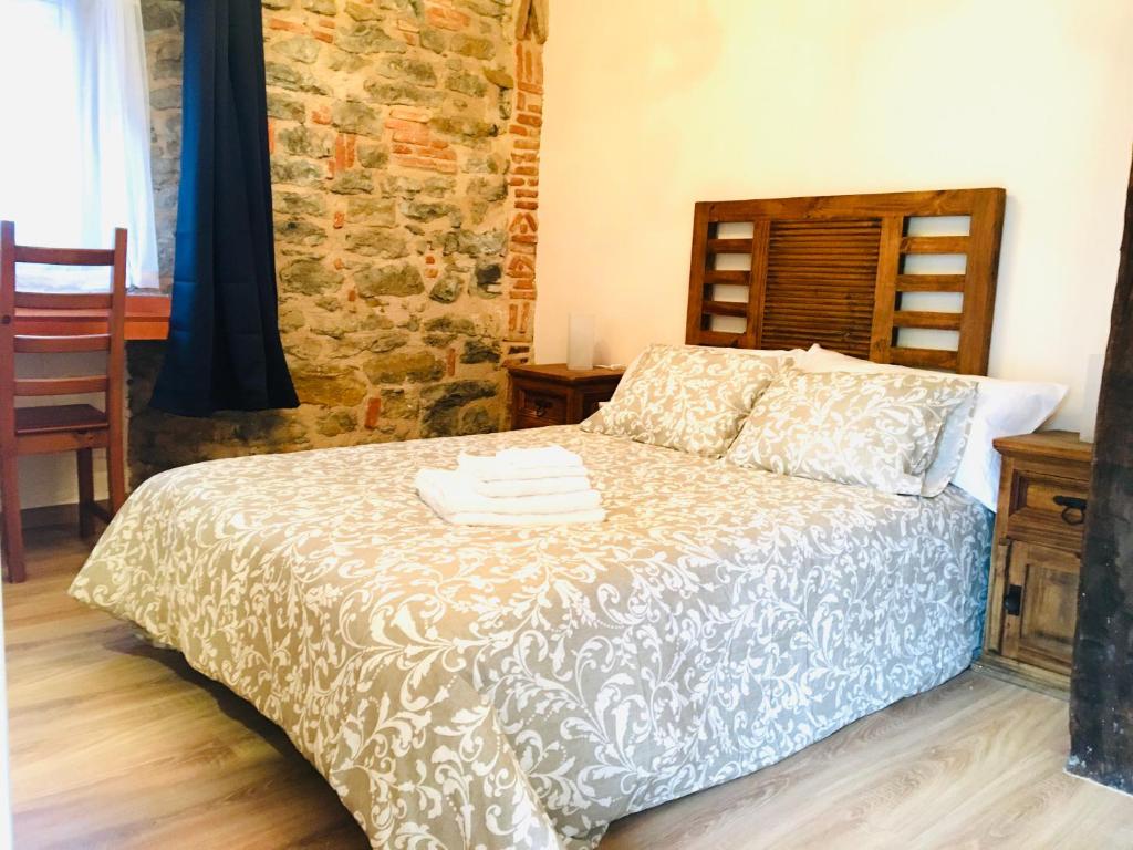 a bedroom with a bed and a stone wall at Hospedaje Albizabal HVI00405 in Amurrio