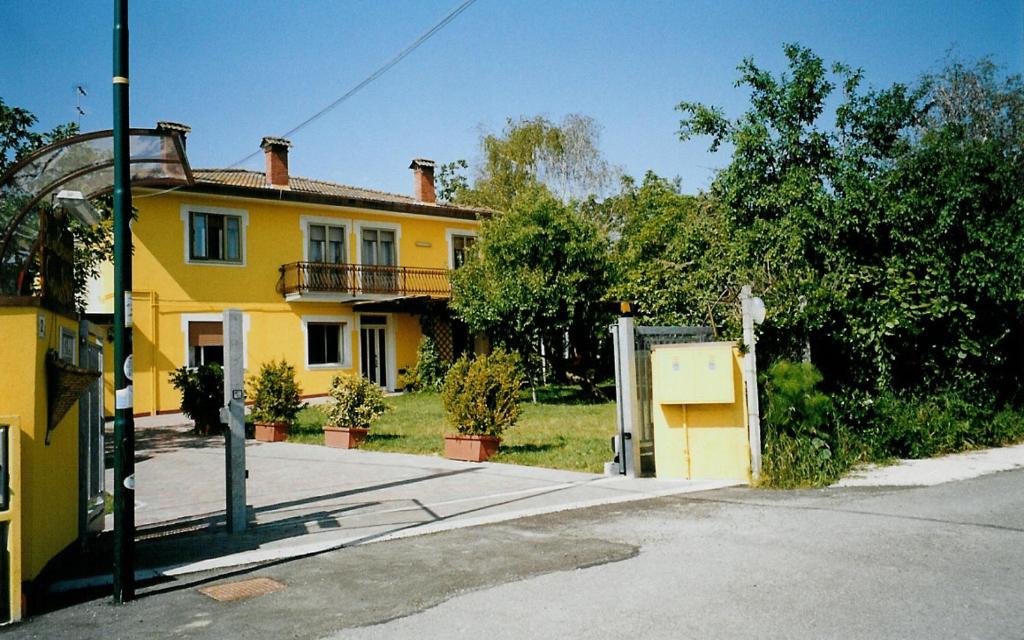 a yellow house sitting on the side of a street at Casa del Miele in Tessera