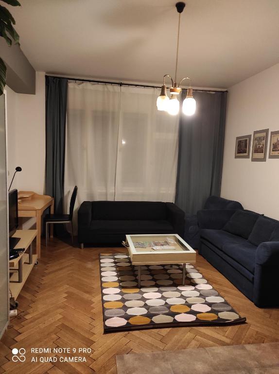 ein Wohnzimmer mit einem Sofa und einem Tisch in der Unterkunft Coronation Apartment in Bratislava