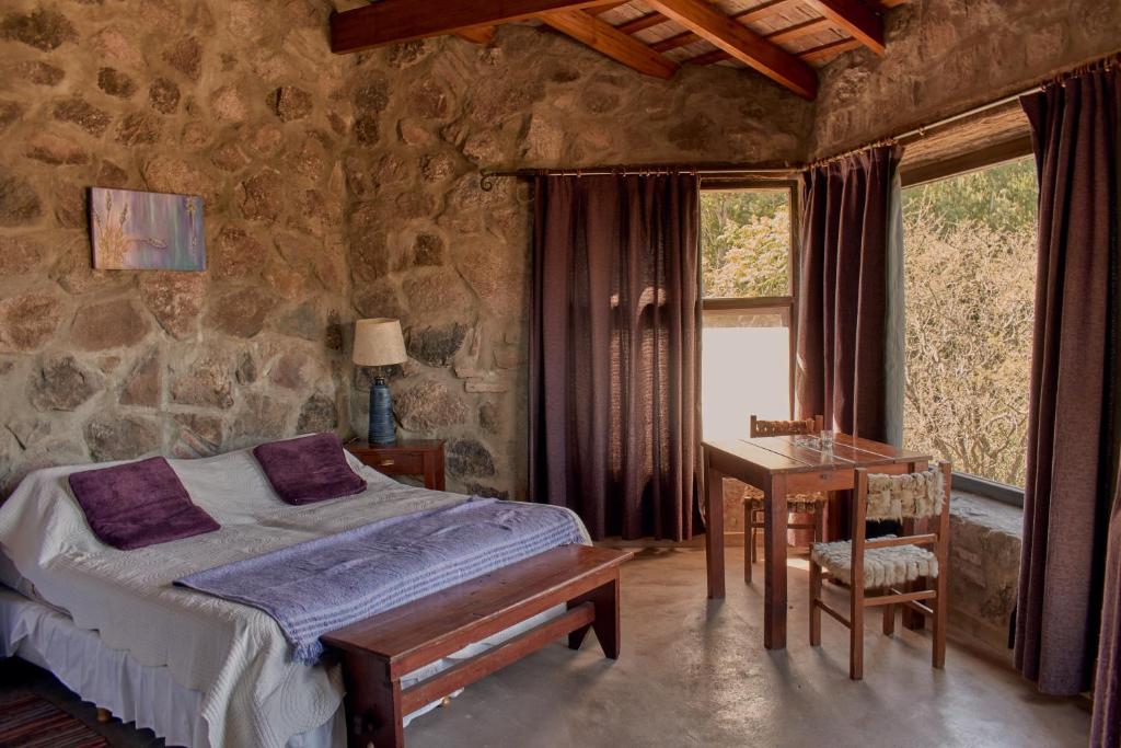 1 dormitorio con cama, escritorio y ventana en Cabañas Las Perdices de Candonga en Agua de Oro