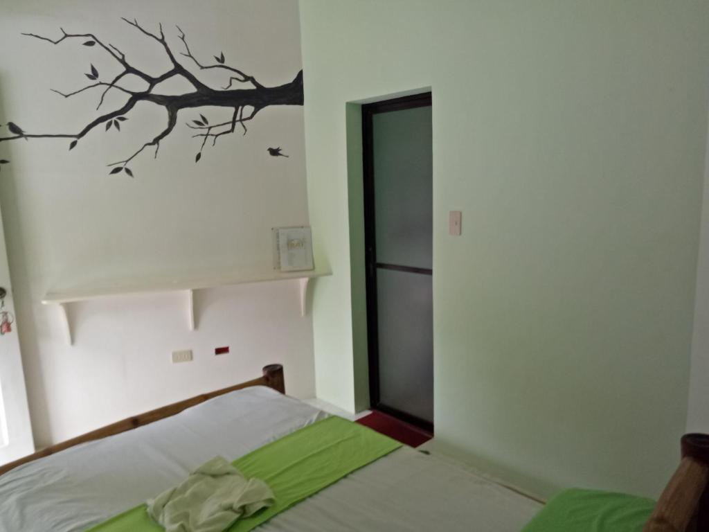 - une chambre avec un lit et un arbre sur le mur dans l'établissement Greenhut Pension & Bar, à Jagna