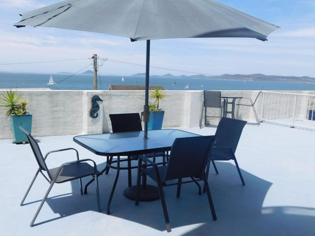 a table and chairs with an umbrella on a patio at The Point, 5, 5-7 Mitchell Street large balcony with great water views in Soldiers Point