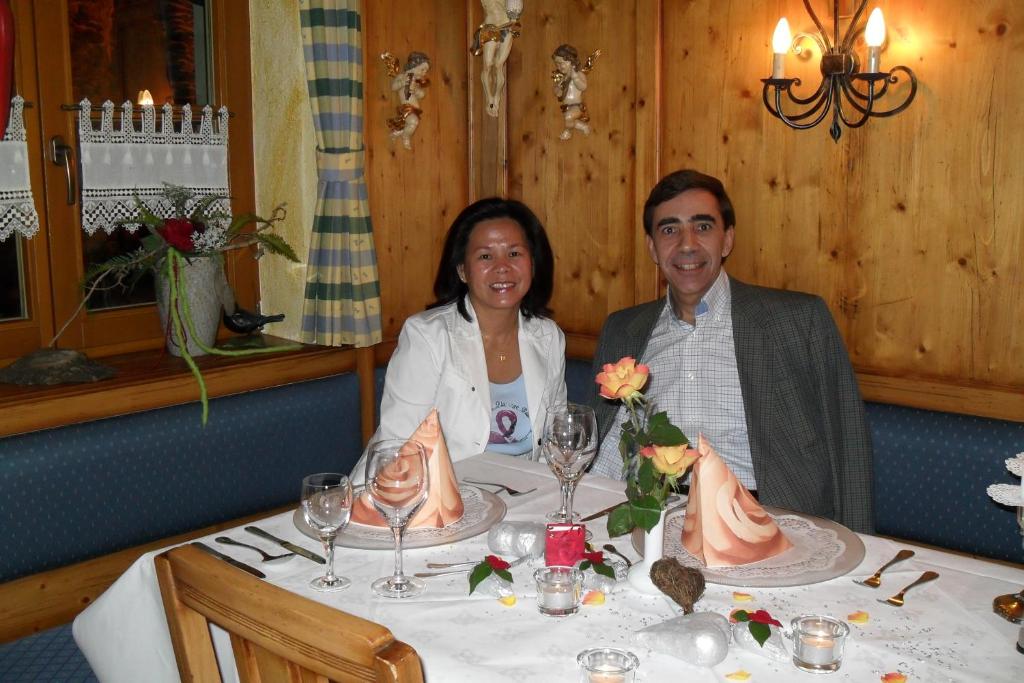 Ein Mann und eine Frau sitzen an einem Tisch in der Unterkunft Landhaus Irma in Bad Füssing