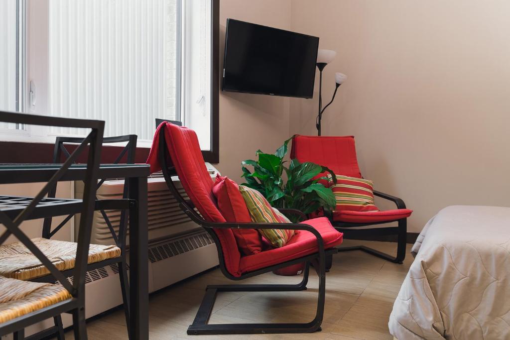 een kamer met 2 stoelen, een tafel en een tv bij Cjour Apartments in Montreal