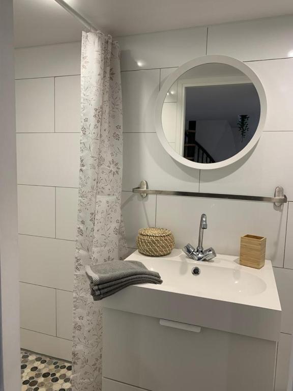 ein weißes Badezimmer mit einem Waschbecken und einem Spiegel in der Unterkunft Loft Luxe La Plaine in Marseille