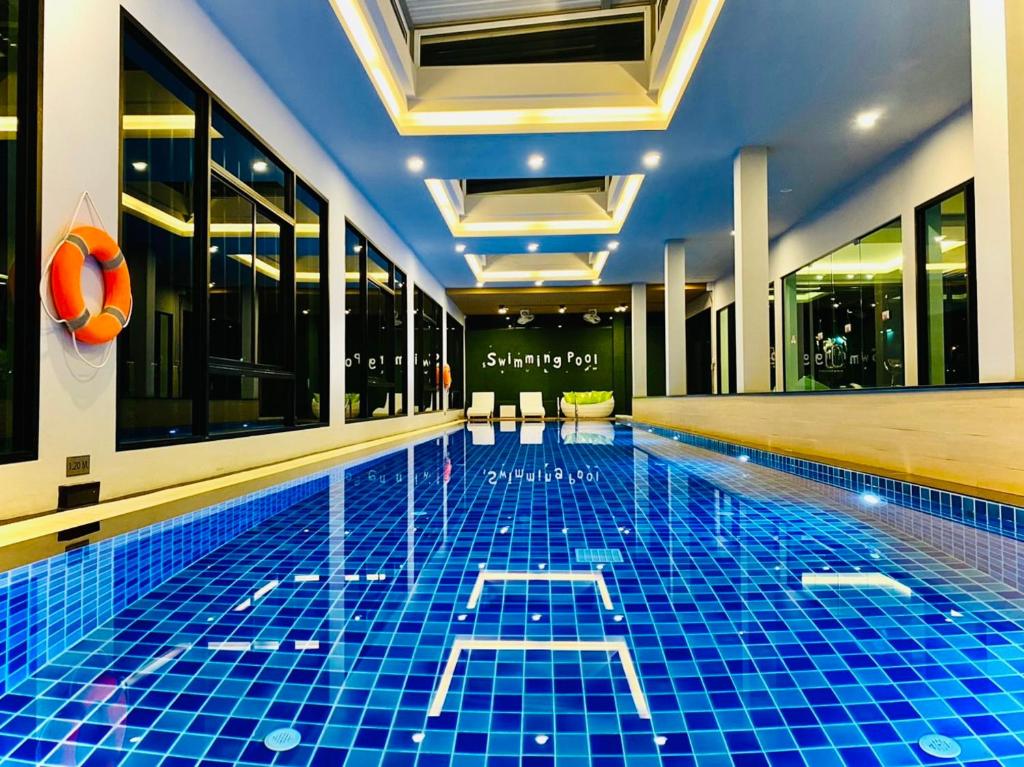 uma piscina com azulejos azuis num hotel em The Vet Boutique Hotel - SHA Extra Plus em San Kamphaeng