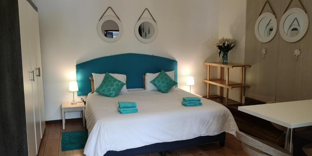 1 dormitorio con 1 cama grande y cabecero azul en a Vue Guesthouse en Somerset West
