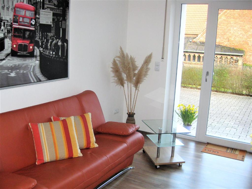 a living room with a leather couch and a glass table at Ferienwohnung Becker in Büren