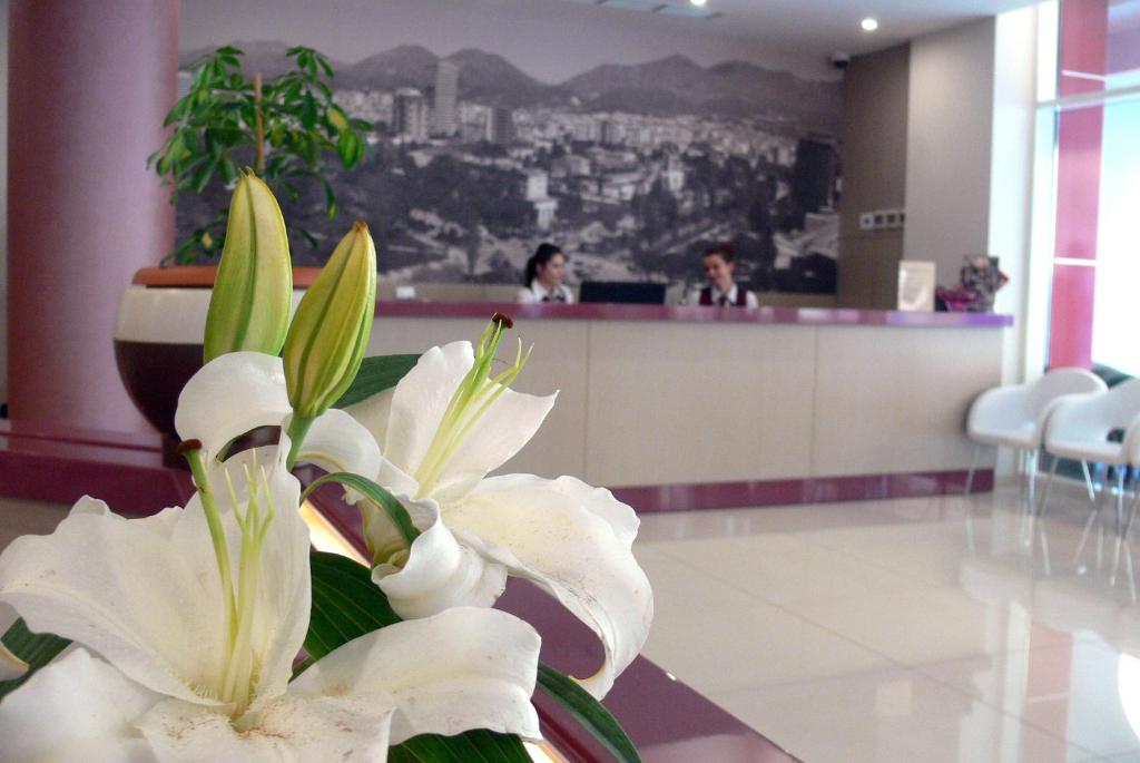 a bouquet of white flowers sitting in a lobby at Sky 2 Hotel Tirana in Tirana
