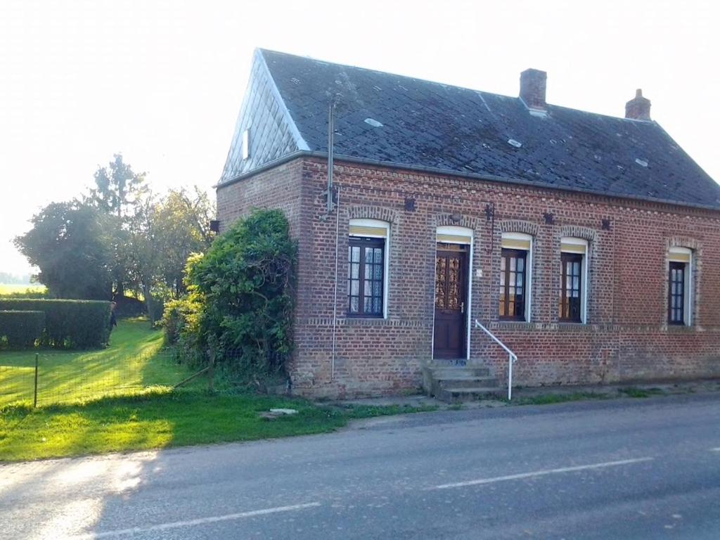 ein altes Backsteinhaus am Straßenrand in der Unterkunft Maison de 3 chambres avec jardin clos et wifi a Mailly Maillet in Mailly-Maillet