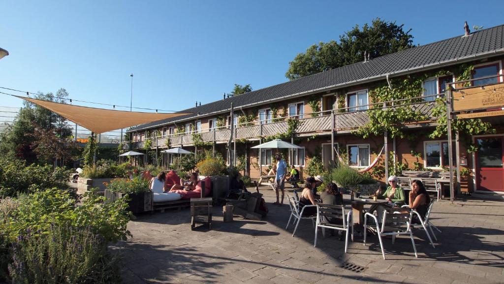 un grupo de personas sentadas fuera de un edificio en Amsterdam Farm Lodge en Ámsterdam