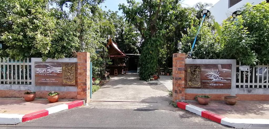 une porte menant à un bâtiment doté d'une clôture blanche dans l'établissement Sun smile(cafe & homestay), à Ubon Ratchathani