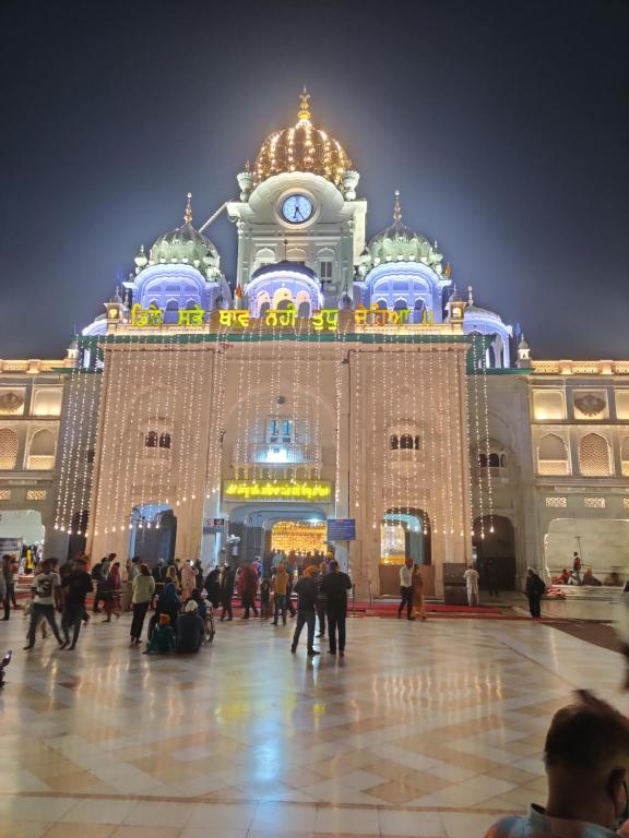 a large building with people in front of it at night at RUJHAN in Amritsar