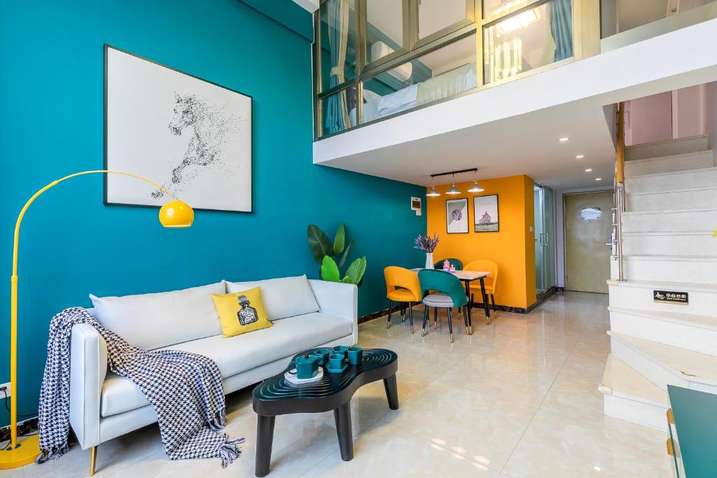uma sala de estar com um sofá branco e uma parede azul em Lavender Apartment Branch em Guangzhou