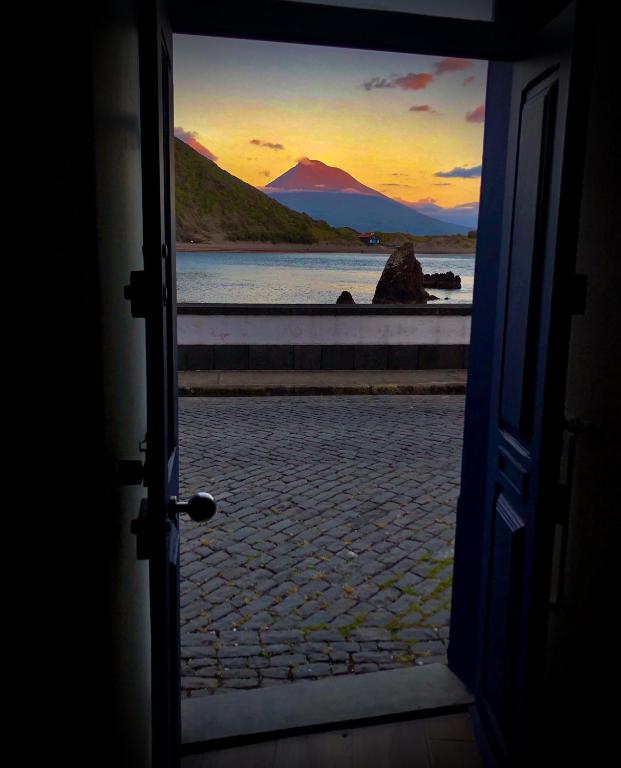 an open door with a view of a body of water at Casa Três Picos in Horta