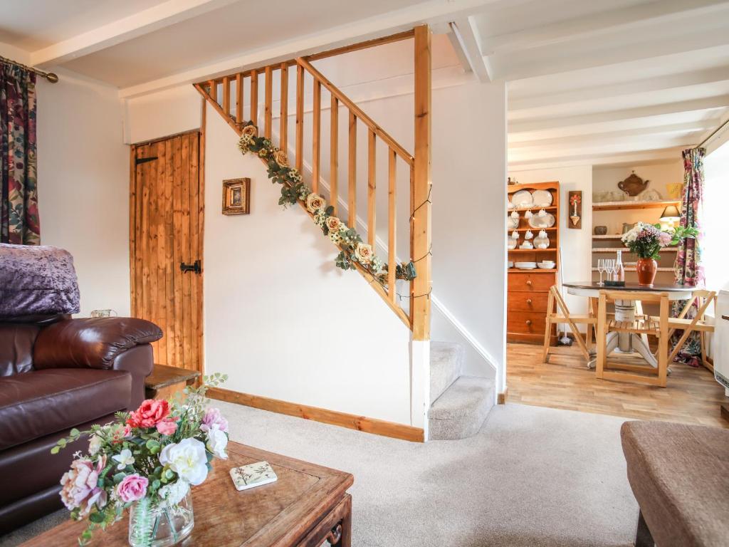 a living room with a staircase and a table at Corner Cottage in Cemaes Bay