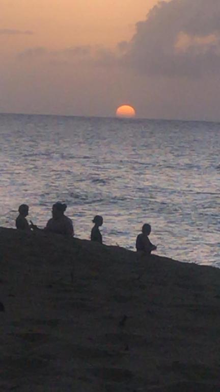 - un groupe de personnes assises sur la plage pour admirer le coucher du soleil dans l'établissement Freandly three bedrooms apartment, à Sosúa