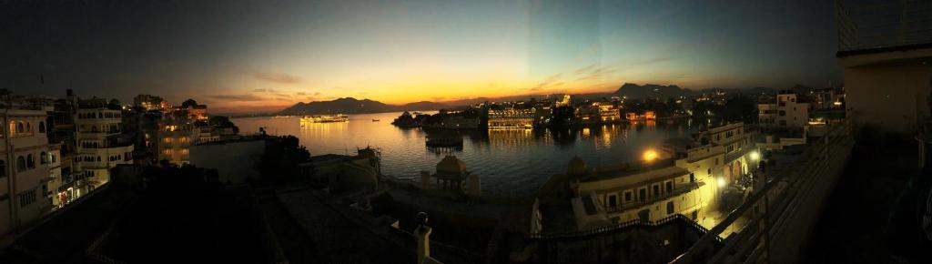 a view of a city at night with the water at Hotel The Tiger in Udaipur