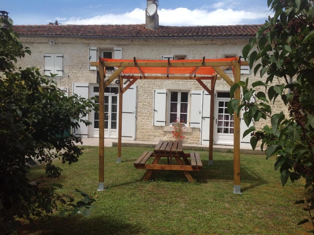 a wooden picnic table in front of a building at La Gravelle in Varaize