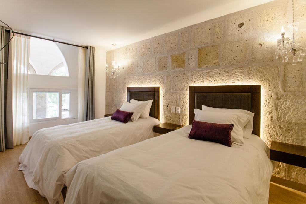 a bedroom with two beds with white sheets at La Plaza Arequipa Hotel Boutique in Arequipa