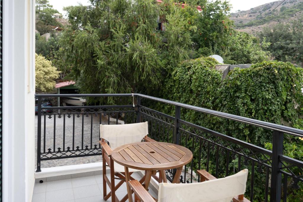 a wooden table and chairs on a balcony at Aretousa in Sougia