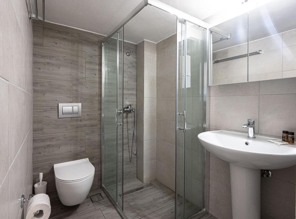 a bathroom with a shower and a toilet and a sink at Aretousa in Sougia