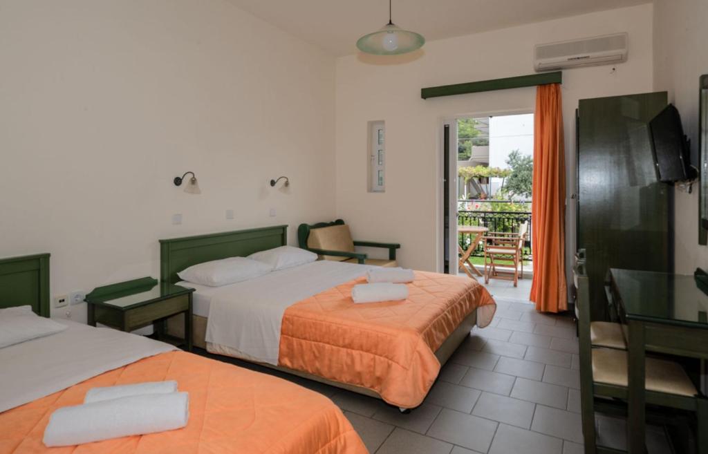 a hotel room with two beds and a balcony at Aretousa in Sougia