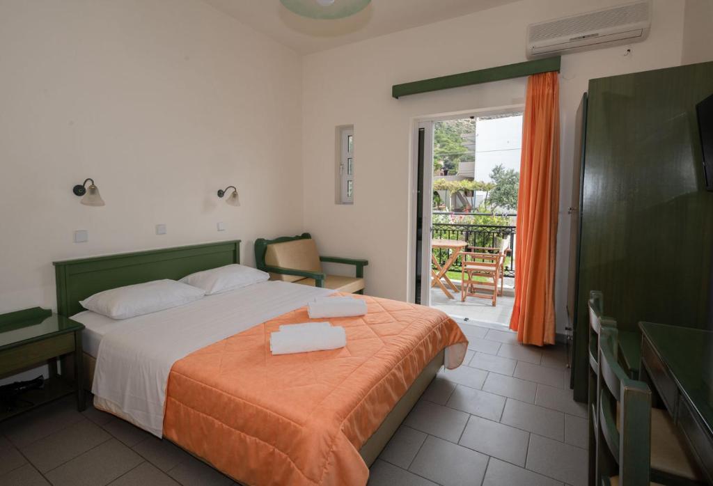 a hotel room with a bed and a balcony at Aretousa in Sougia