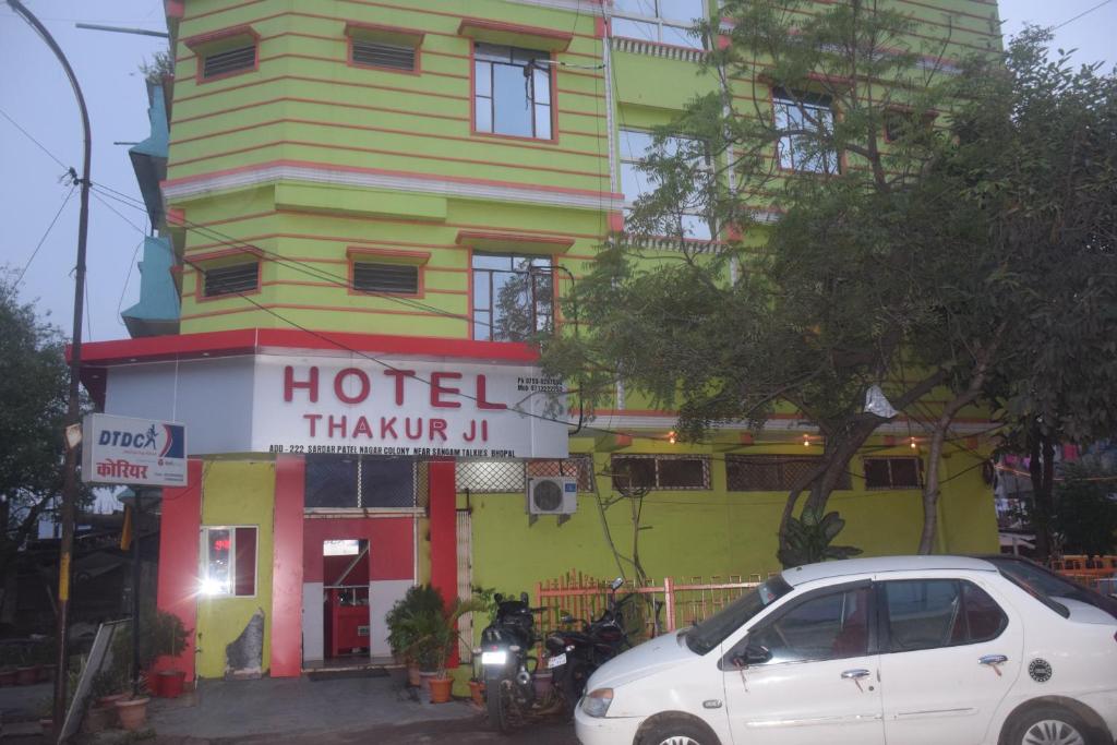un coche blanco estacionado frente a un hotel en Hotel Thakur Ji en Bhopal