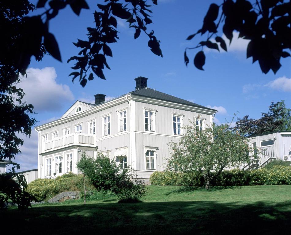 ein großes weißes Haus auf einem grünen Rasen in der Unterkunft Söråkers Timrå Herrgård in Söråker